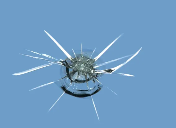 Close-up of a stone-chip star break in a windscreen before repair