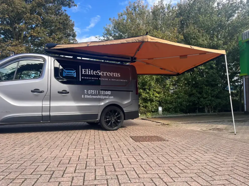 The EliteScreens van set up with its awning at a job